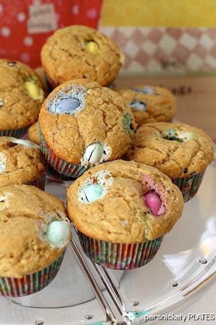 Peanut Butter M&M Muffins a pile of peanut butter muffins filled with pastel M&Ms.
