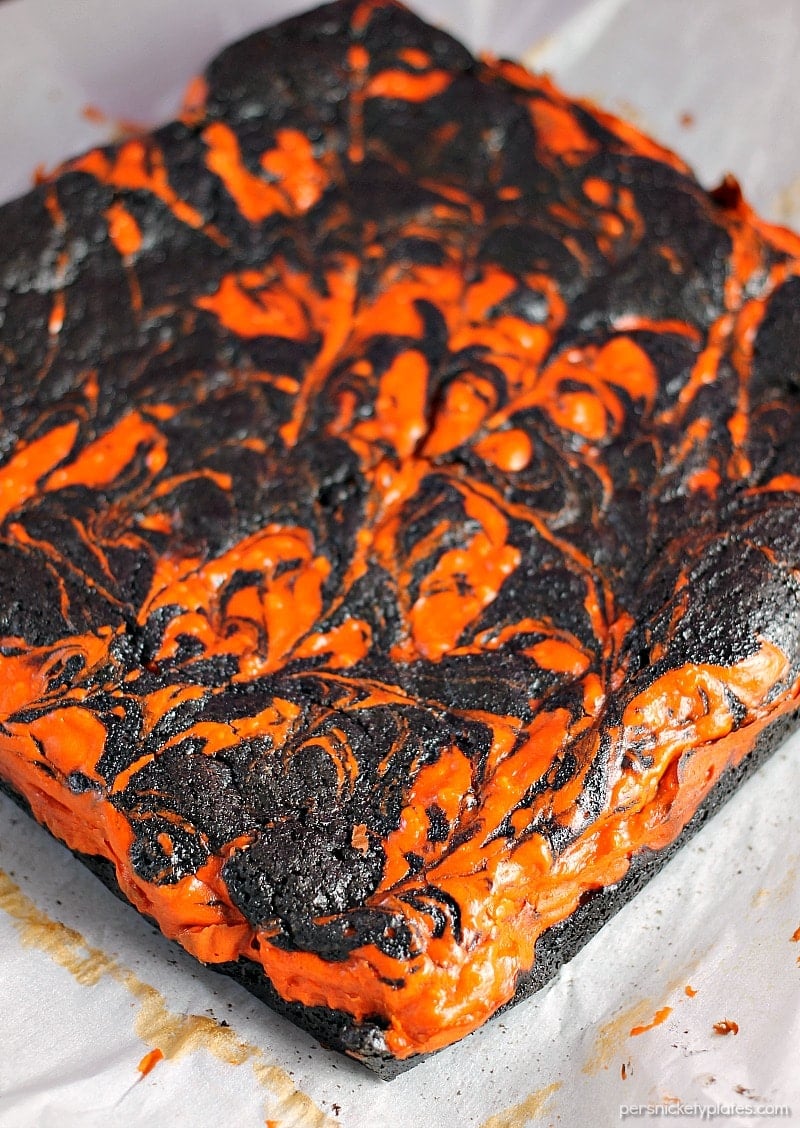 Halloween Cream Cheese Swirl Brownies have a layer of rich, dark chocolate brownie topped with a layer of orange cheesecake then swirled together for a spooky treat. | Persnickety Plates