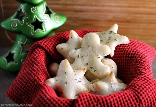 a red basket filled with Christmas shaped garlic herb dinner rolls
