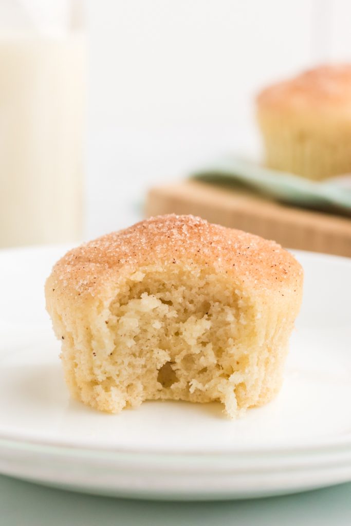 french breakfast muffin with a bite missing sitting on a white plate.