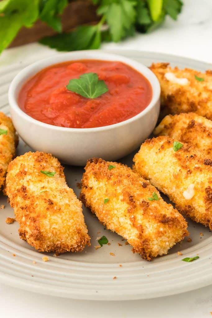 plate of air fryer cheese sticks with marinara.