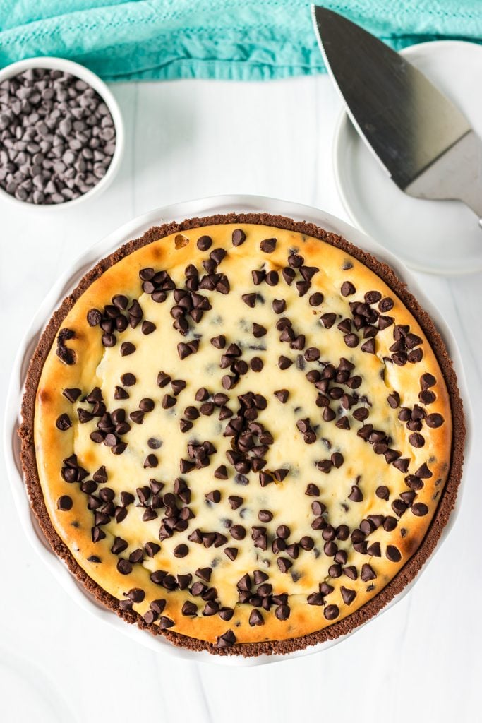 overhead shot of a chocolate chip cheesecake next to a serving knife.