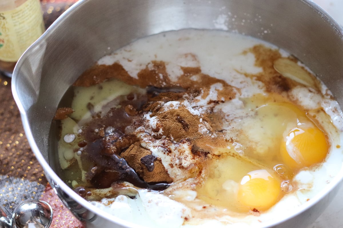 Cinnamon Quick Bread could be called Cinnamon VERY Quick Bread! A simple, from scratch quick bread topped with a cinnamon streusel swirl. | www.persnicketyplates.com mixing bowl full of eggs, flour, cinnamon for cinnamon quick bread