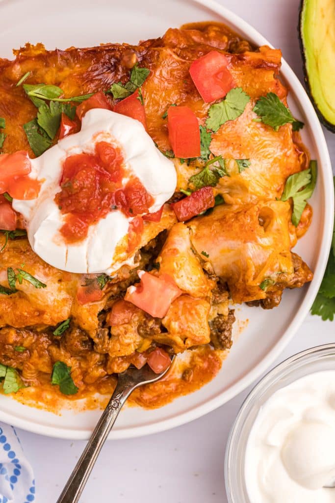beef enchiladas with a fork taking a bite.