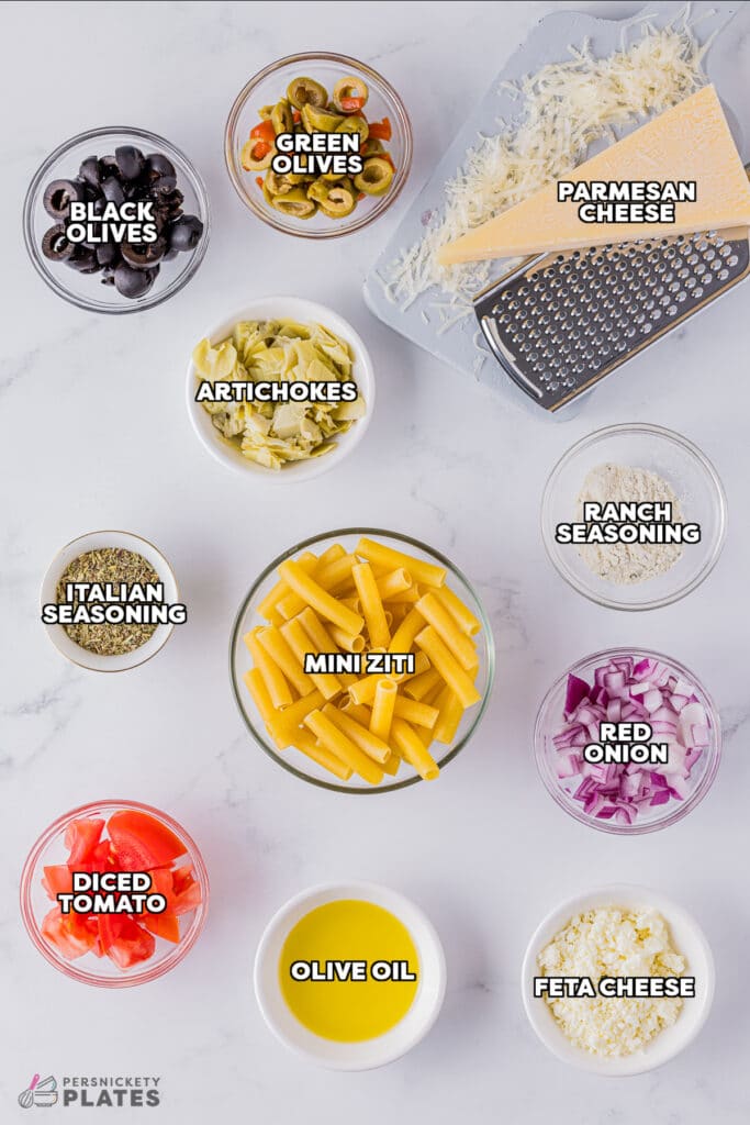 overhead shot of labeled ingredients laid out to make greek pasta salad.