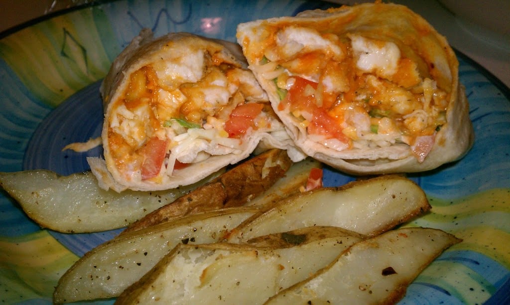If you like the Buffalo Ranch Chicken Wrap from Buffalo Wild Wings, you'll love this lightened up homemade version! Lightly breaded buffalo chicken pieces wrapped up in a soft tortilla with ranch dressing, shredded lettuce, cheese, and tomatoes make a great dinner or the perfect game day meal! | www.persnicketyplates.com buffalo ranch wrap with fries