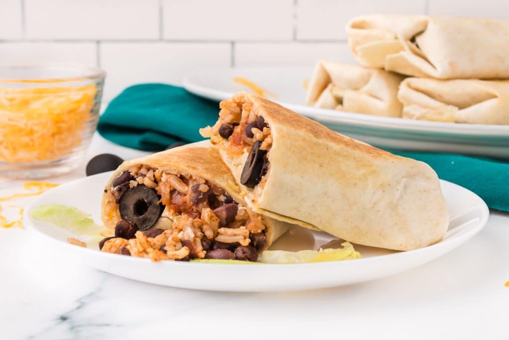 black bean tortilla cut in half on a white plate.