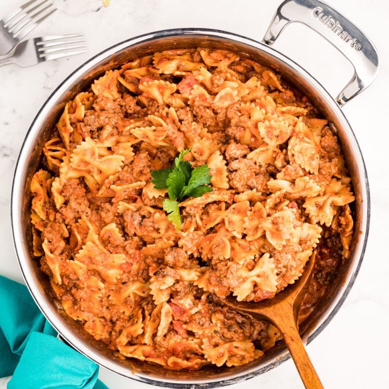 overhead shot of bow tie pasta lasagna skillet with a spoon.