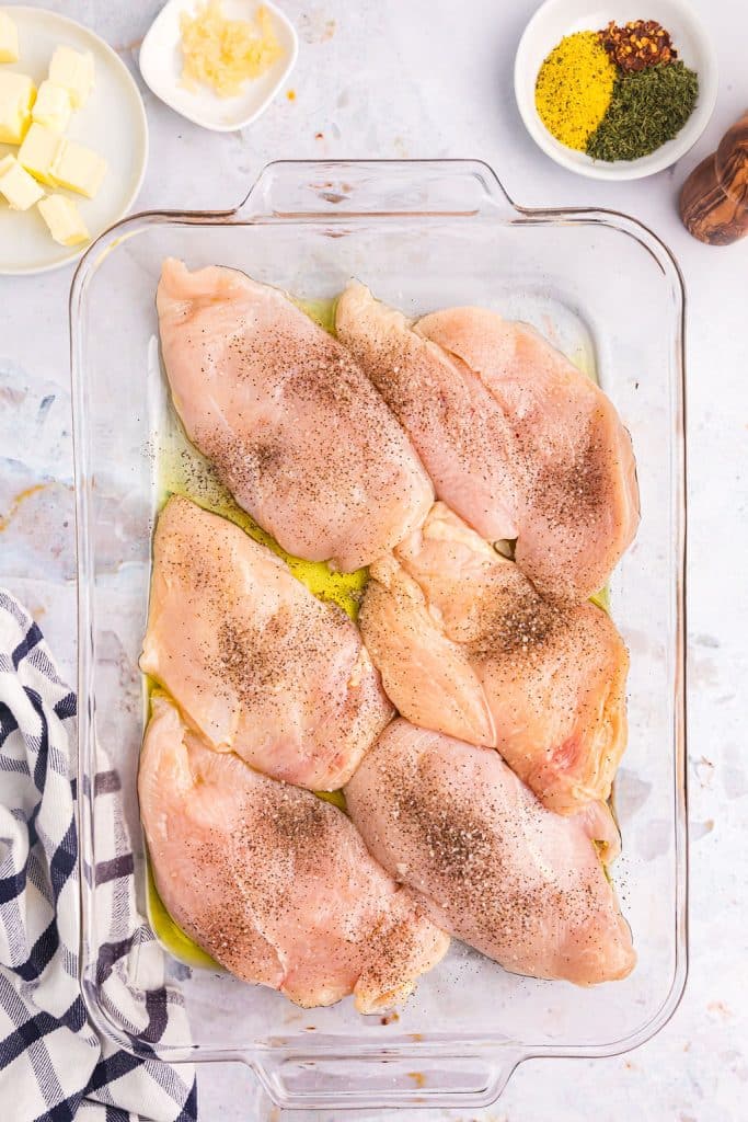 overhead shot of raw, seasoned chicken breasts in a baking dish.