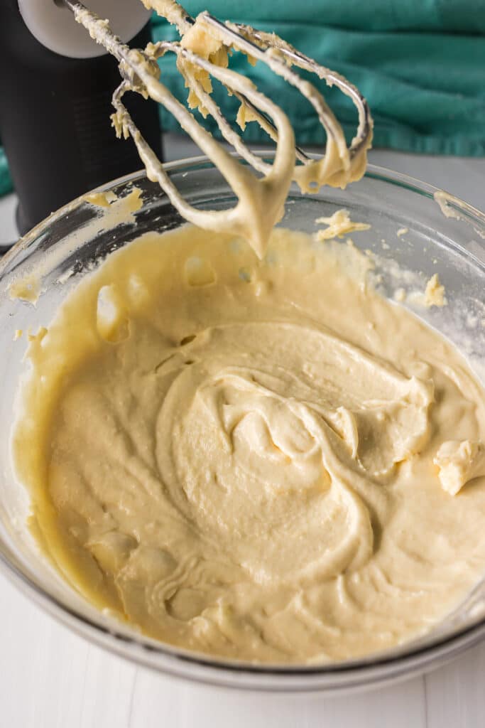 cake batter and mixer in a glass mixing bowl.