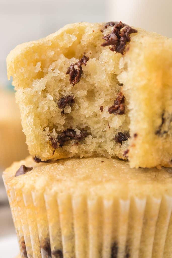 stack of chocolate chip muffins with a bite missing from top.