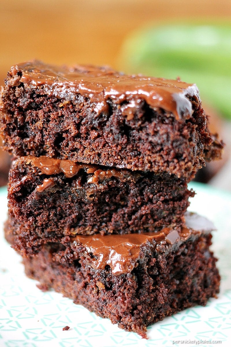 stack of three chocolate frosted zucchini brownies.