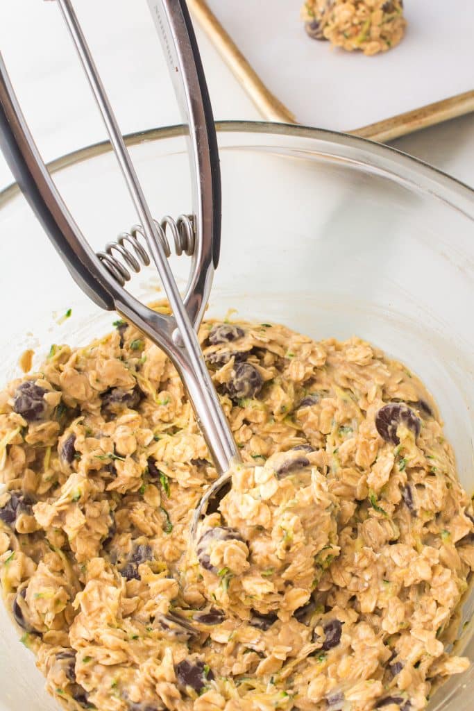 cookie scoop scooping dough from a mixing bowl.
