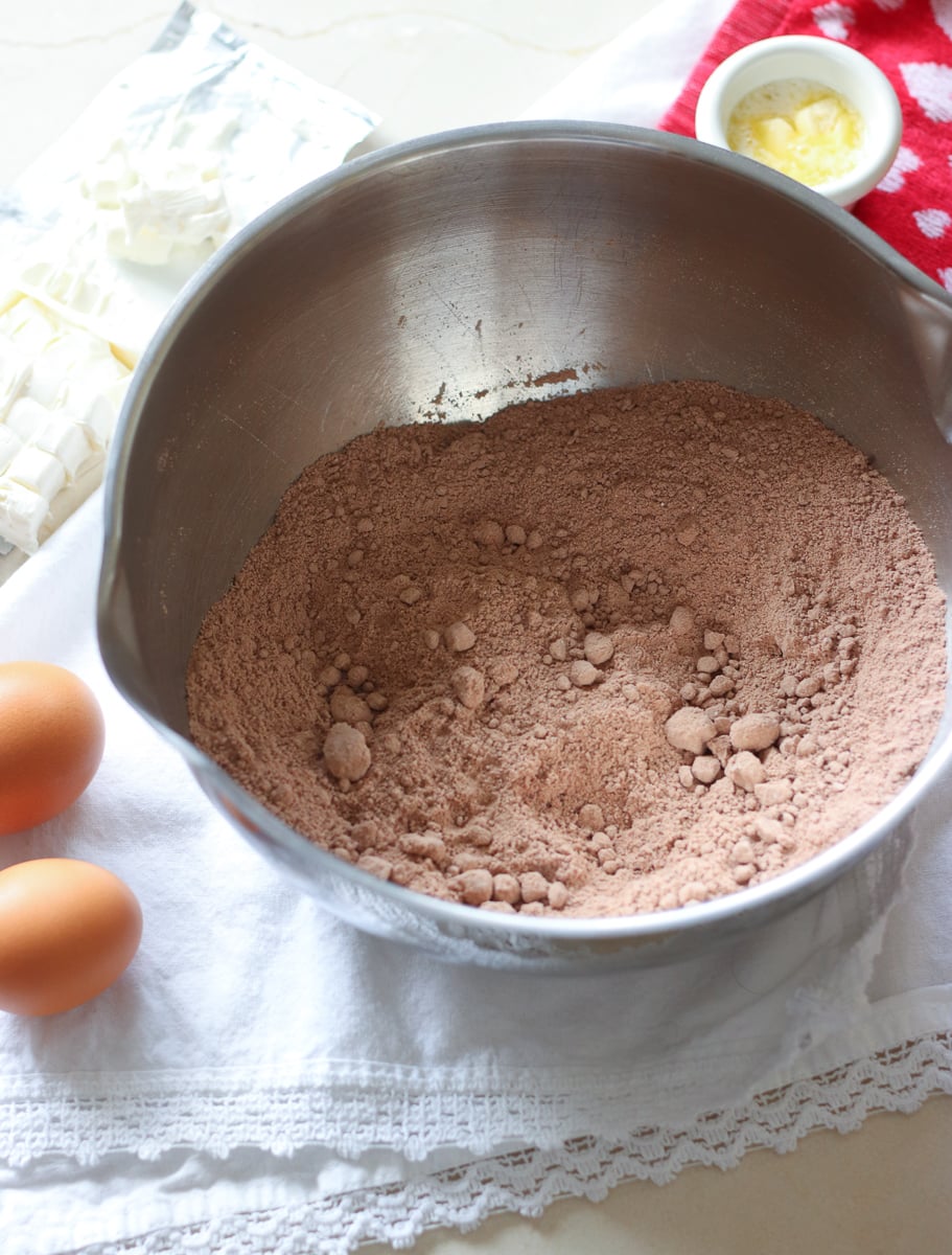 mixing bowl with ingredients for red velvet cream cheese swirl cookies