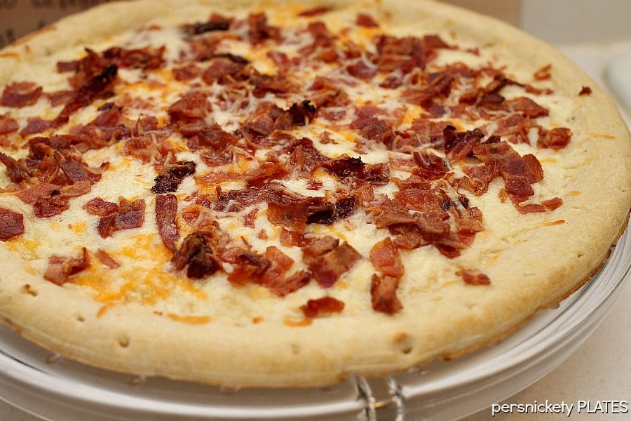This BLT Pizza is semi-homemade and topped with cheese, bacon, lettuce, and tomatoes then drizzled with ranch dressing - a super easy meal for pizza night at home! | www.persnicketyplates.com melted cheese and bacon bits on pizza crust for blt pizza