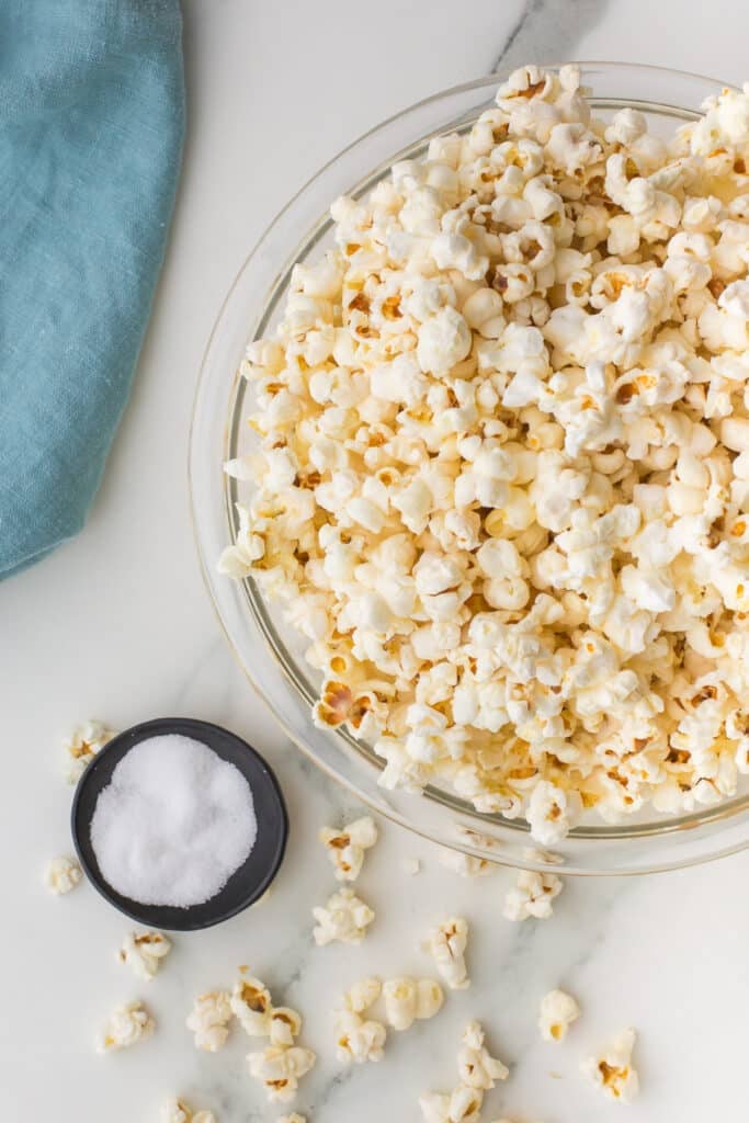 bowl of popcorn next to a bowl of salt.