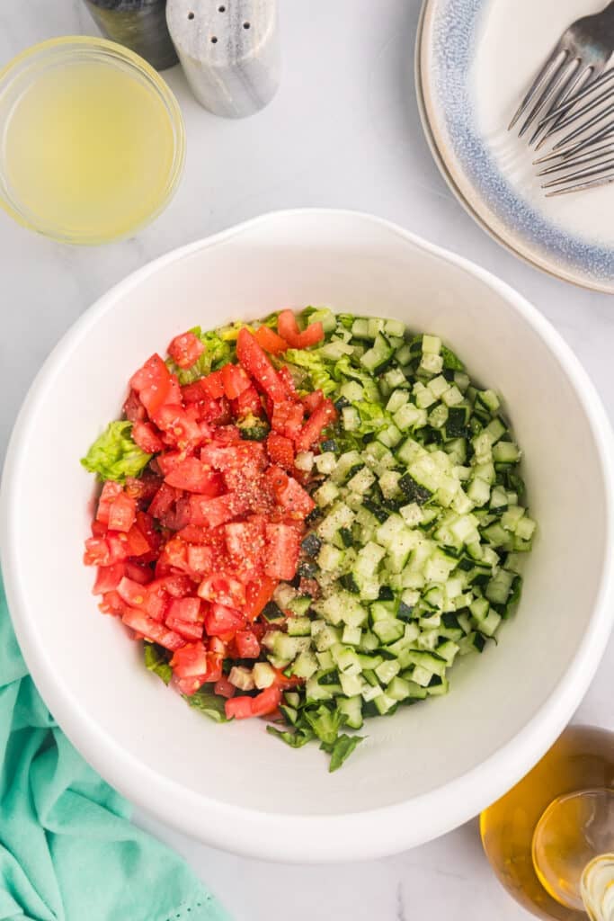 diced cucumbers and tomatoes in a mixing bowl.