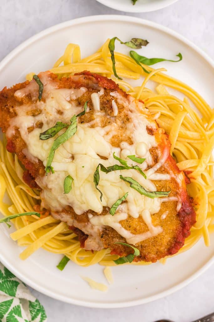 mozzarella chicken on a bed of fettuccine noodles.