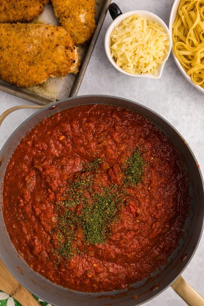 crushed tomatoes in a skillet sprinkled with parsley.