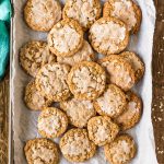 pile of iced oatmeal cookies on a baking sheet