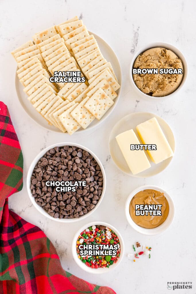 Ingredients for Christmas crack: saltine crackers, butter, brown sugar, chocolate chips, peanut butter, and holiday sprinkles.