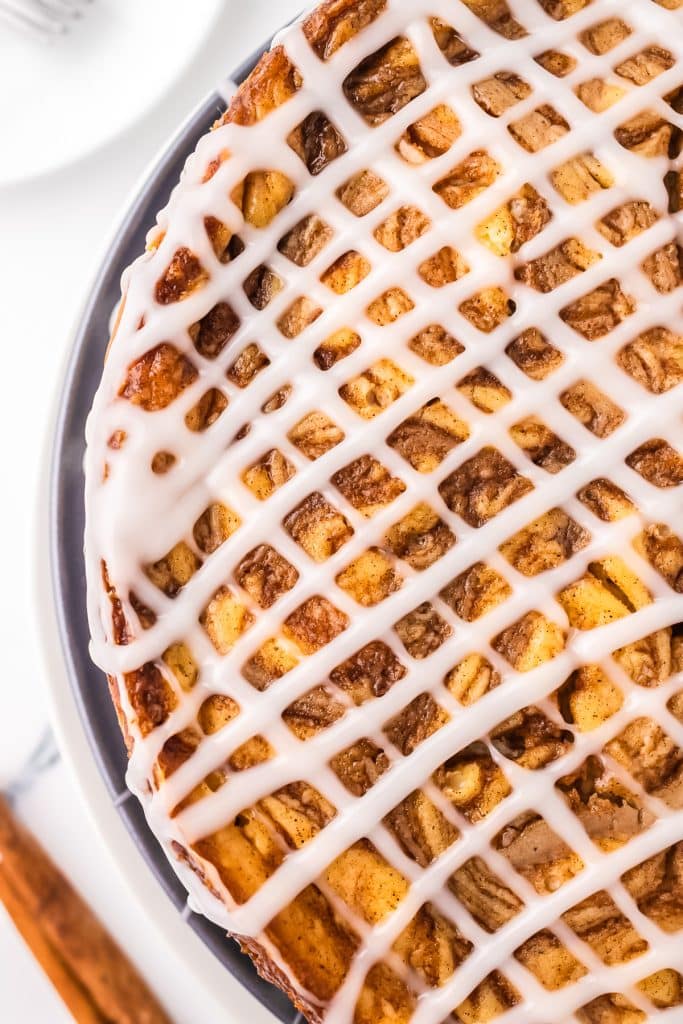 overhead shot of cinnamon roll cheesecake drizzled with icing.