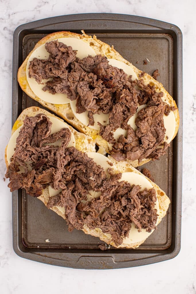 cooked steak on sliced loaf of bread.