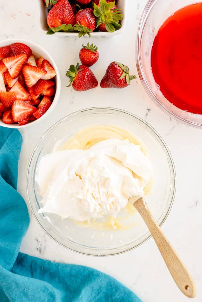 whipped topping being folded into cream cheese.