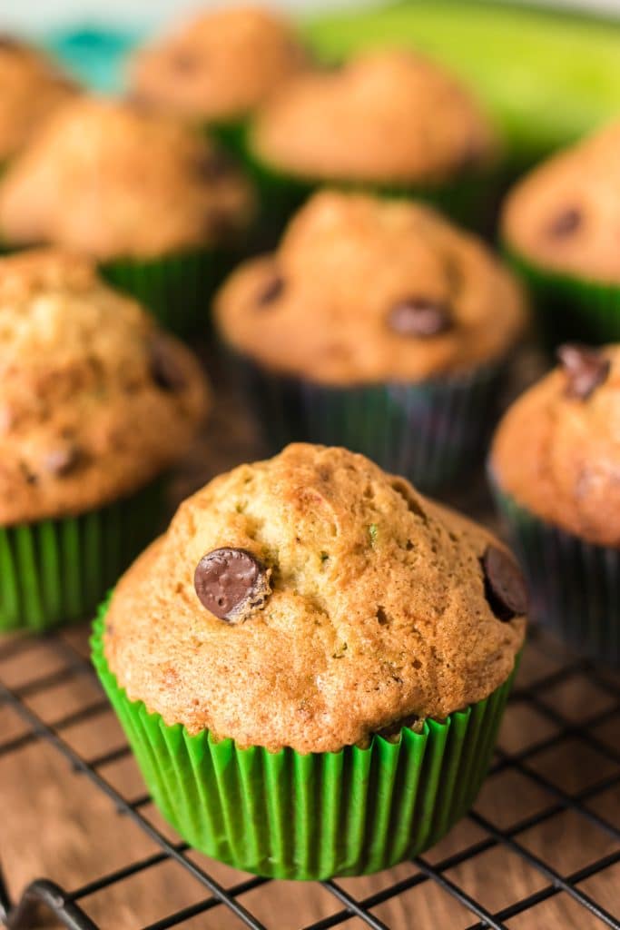 chocolate chip zucchini muffins on a wire cooling rack.