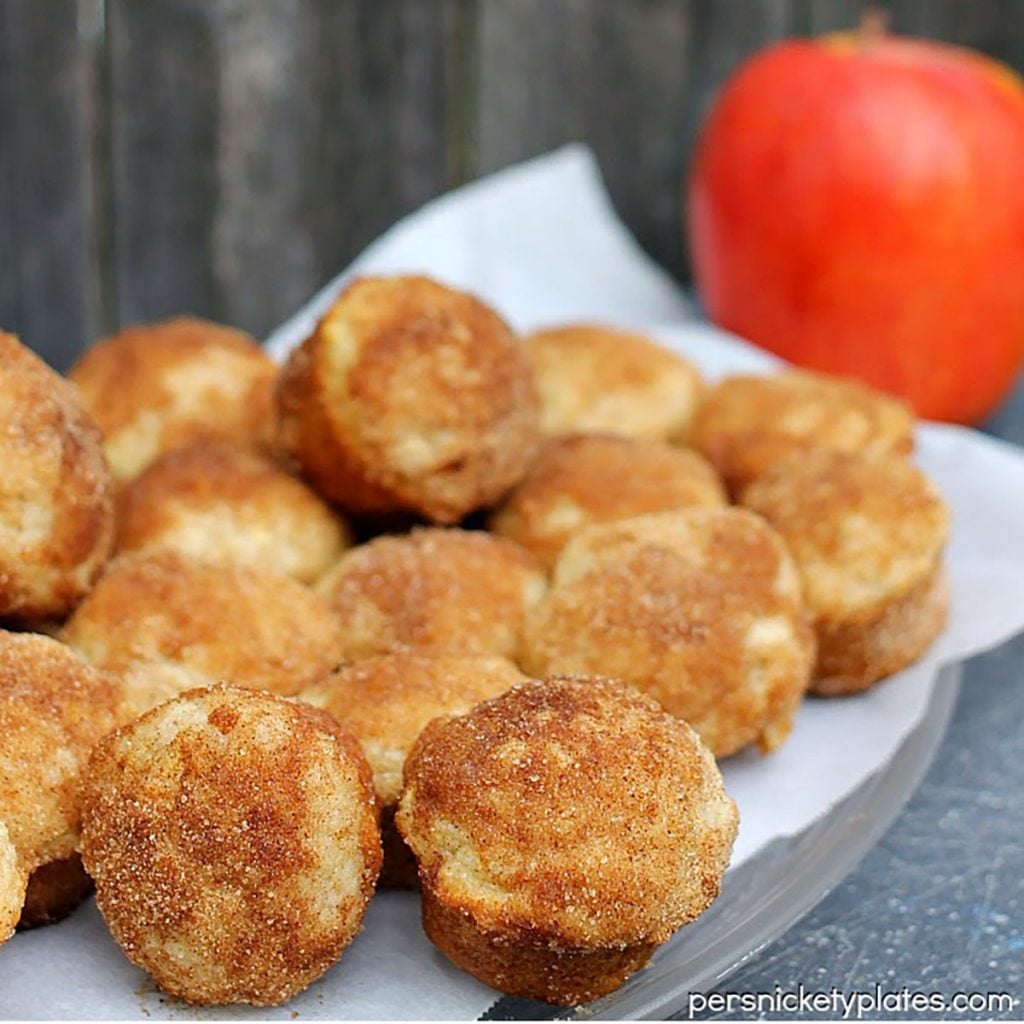 plate of mini muffins with an apple in the background