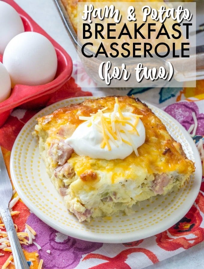serving of ham & potato breakfast casserole on a plate with eggs in the background