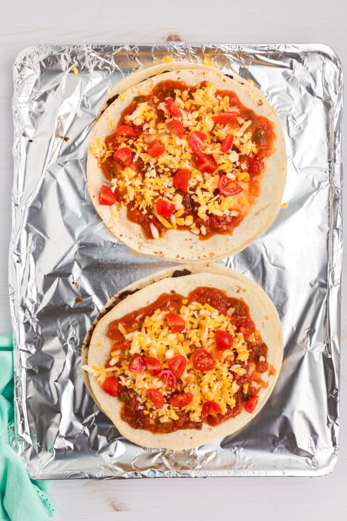two mexican pizzas before baking on foil.
