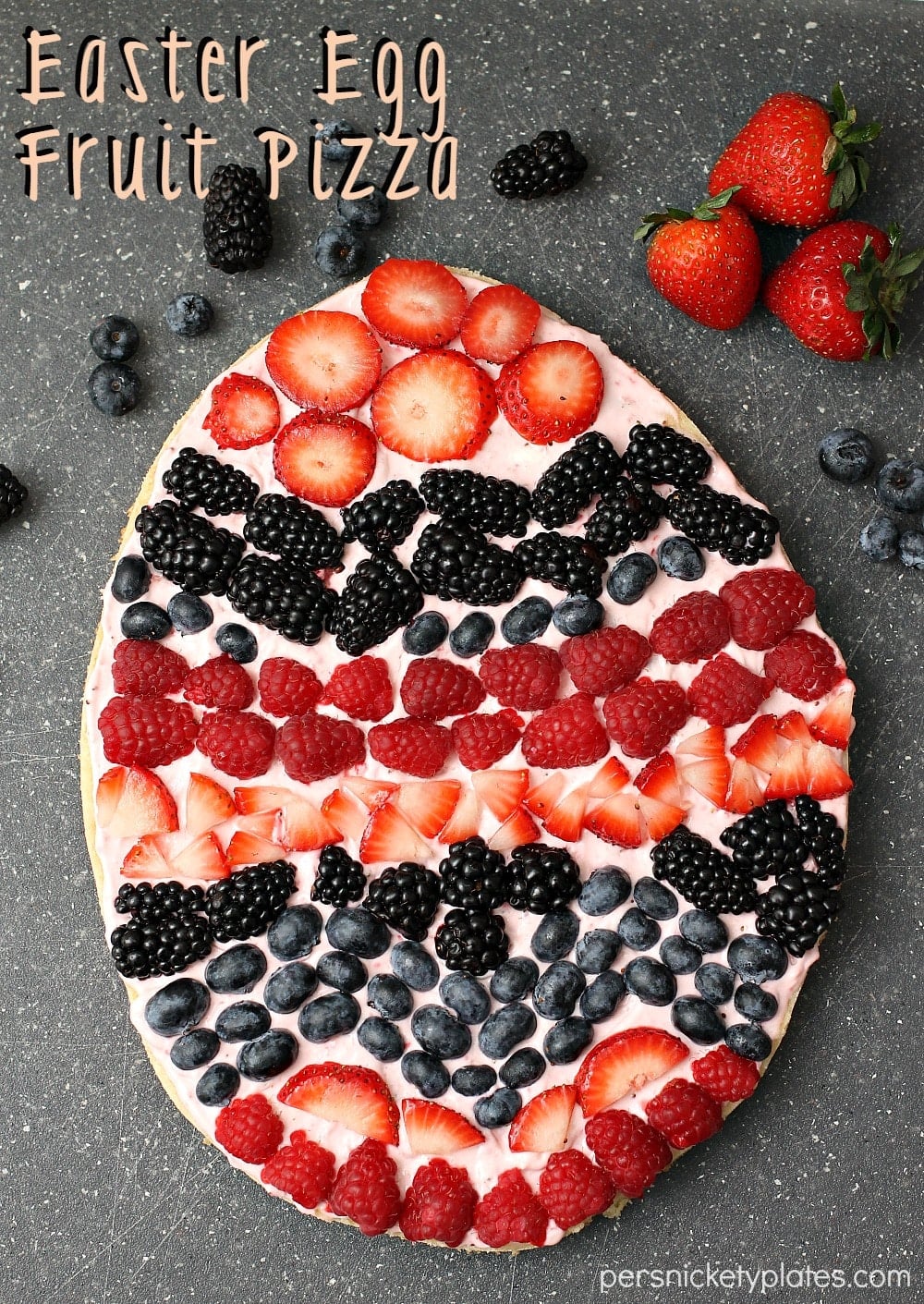 A festive Easter egg sugar cookie fruit "pizza" with strawberry cream cheese frosting. You can make it super simple with a sugar cookie mix or make it from scratch. | Persnickety Plates