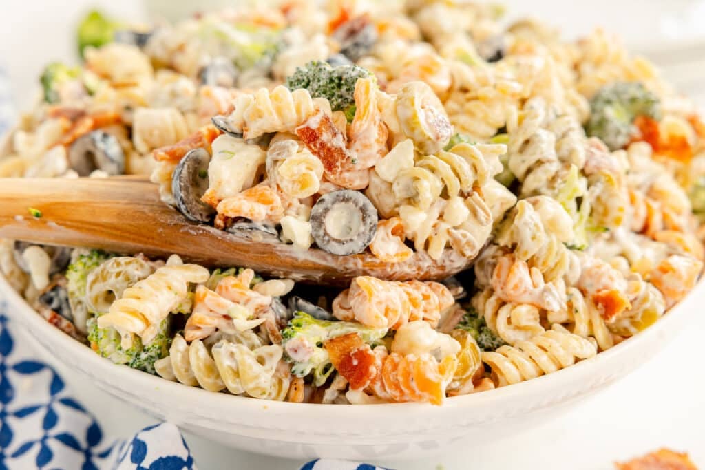 serving dish of bacon ranch pasta salad with a wooden spoon.