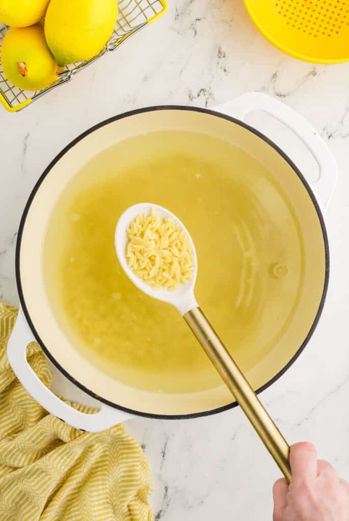 cooked orzo being lifted from a pot.