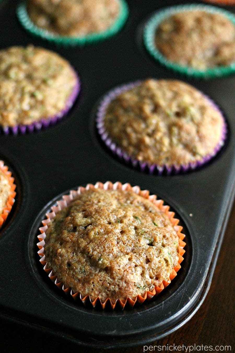 apple cinnamon zucchini muffins in muffin tray overhead shot of pan of muffins.