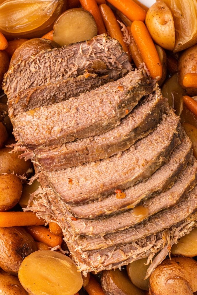 sliced eye of round roast over carrots & potatoes.