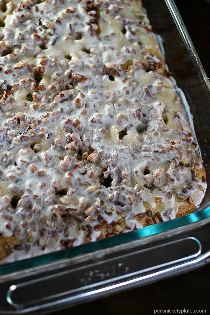 Pistachio Cake starts with a cake mix so it’s super easy and always a crowd pleaser. I’ve never made this cake without being asked for the recipe! Topped with pecans and filled with delicious pistachio pudding, this pistachio pudding cake is simple yet irresistible! | www.persnicketyplates.com