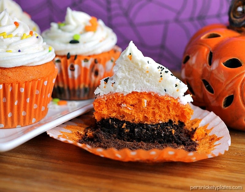 Brownie Bottom Halloween Cupcakes have a layer of dark chocolate brownie topped with orange cake batter and finished off with buttercream and sprinkles. They are the perfect mix of semi-homemade and "from scratch" to be easy but really fun and festive for your next Halloween party! | Persnickety Plates