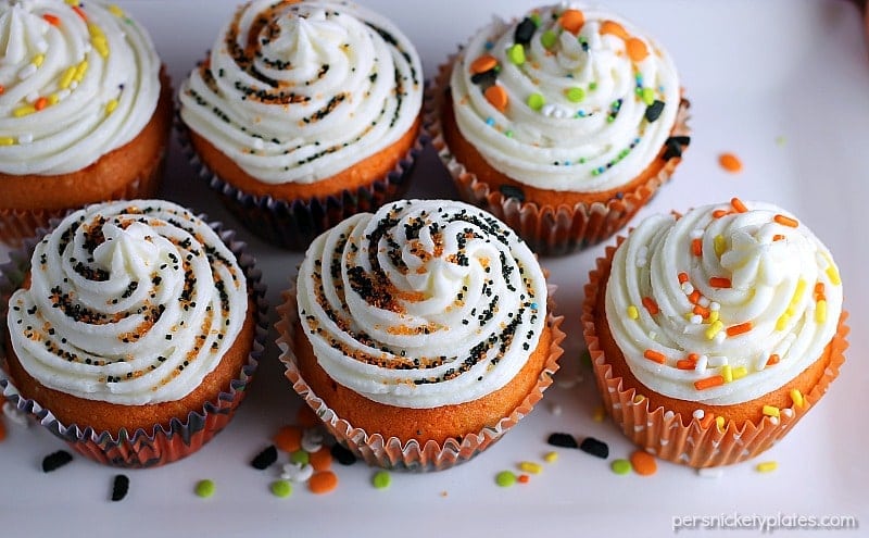 Brownie Bottom Halloween Cupcakes have a layer of dark chocolate brownie topped with orange cake batter and finished off with buttercream and sprinkles. They are the perfect mix of semi-homemade and "from scratch" to be easy but really fun and festive for your next Halloween party! | Persnickety Plates