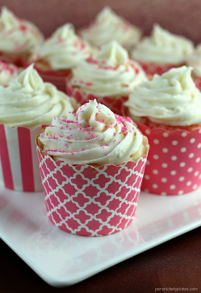 Strawberry Jello Poke Cupcakes start with a white cake mix but are jazzed up when you poke holes in them and pour on some strawberry Jello. It makes for a really moist, flavorful, and pretty cupcake! | Persnickety Plates