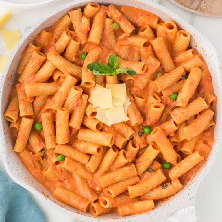 overhead shot of vodka rigatoni in a pan topped with parmesan.