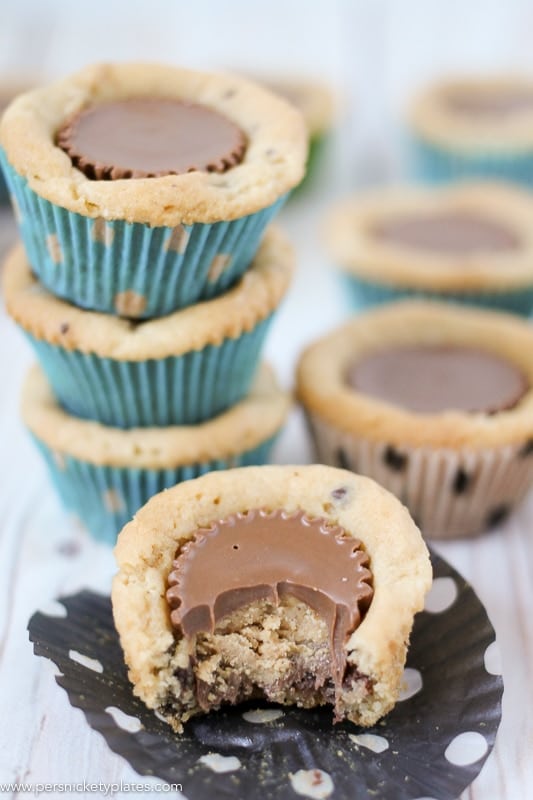 Chocolate Chip Peanut Butter Cookie Cups are only two ingredients and are ready in just 20 minutes. Perfect for a last minute bake sale, class treat, or craving! | www.persnicketyplates.com #easydessert #cookie #cookiecups #semihomemade #dessert stack of cookie cups with one missing a bite