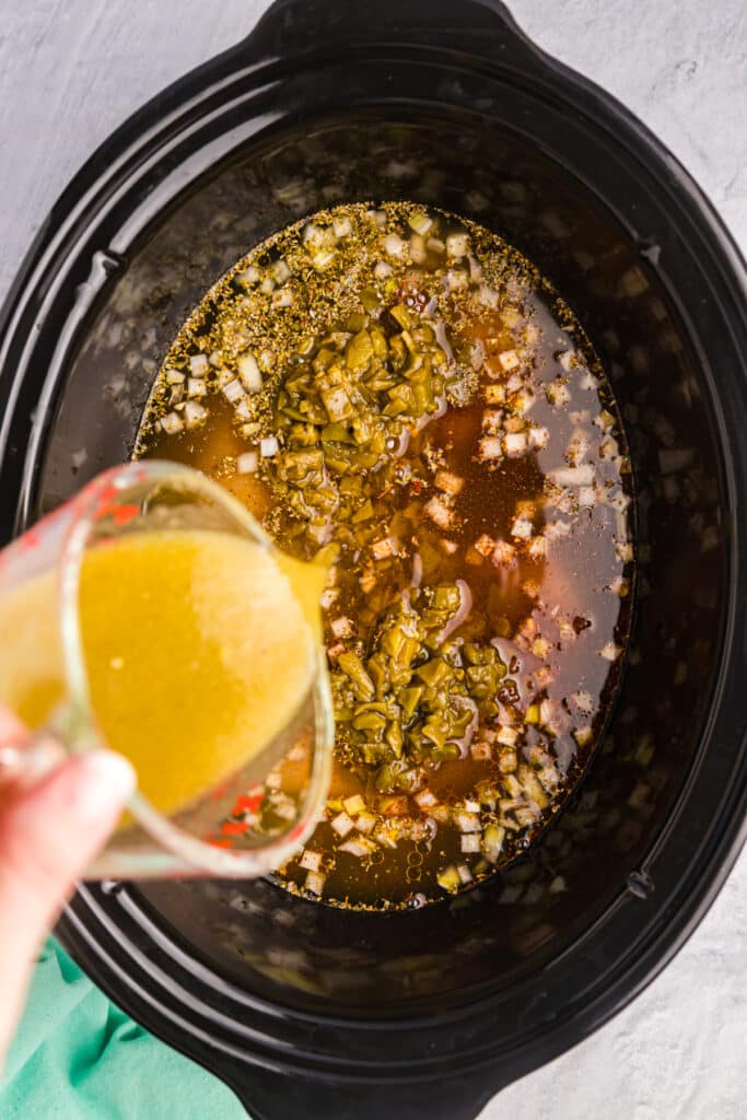 sauce pouring into a slow cooker.