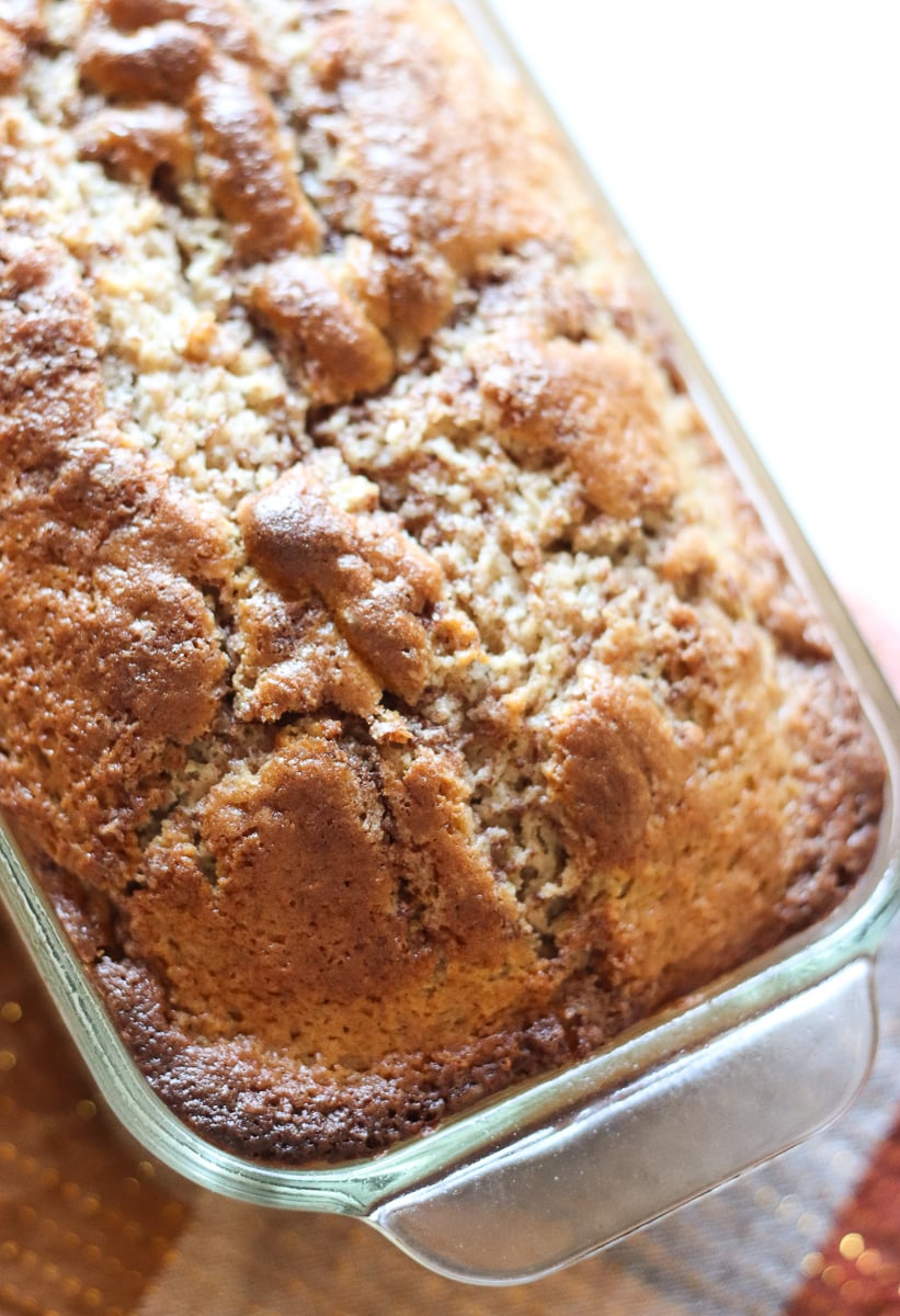 Cinnamon Quick Bread could be called Cinnamon VERY Quick Bread! A simple, from scratch quick bread topped with a cinnamon streusel swirl. | www.persnicketyplates.com loaf of cinnamon quick bread in a glass loaf pan