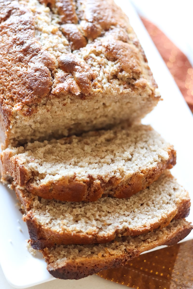 Cinnamon Quick Bread could be called Cinnamon VERY Quick Bread! A simple, from scratch quick bread topped with a cinnamon streusel swirl. | www.persnicketyplates.com loaf of cinnamon swirl quick bread on white platter