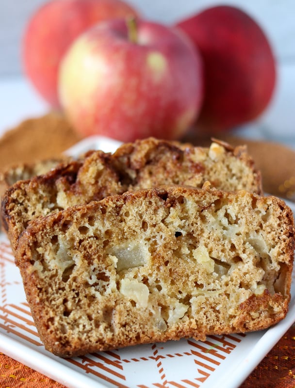 apple bread sliced on plate with apples in background