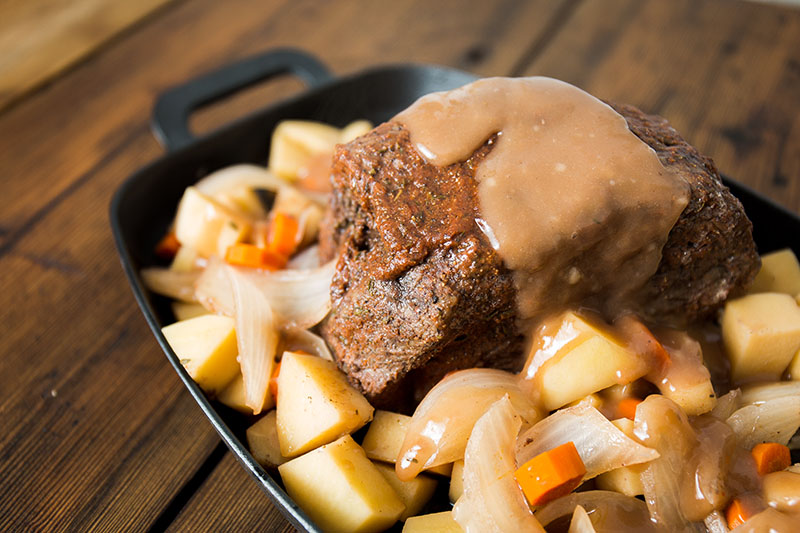 platter of pot roast topped in gravy