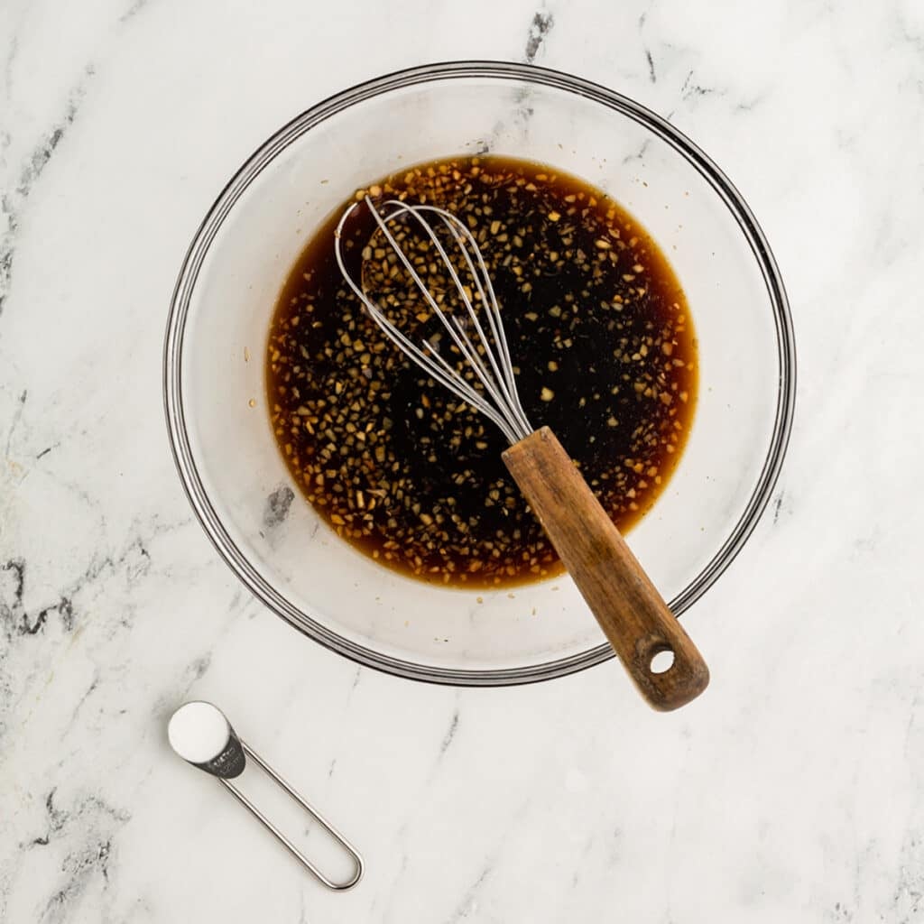 brown sauce in a bowl with a whisk.