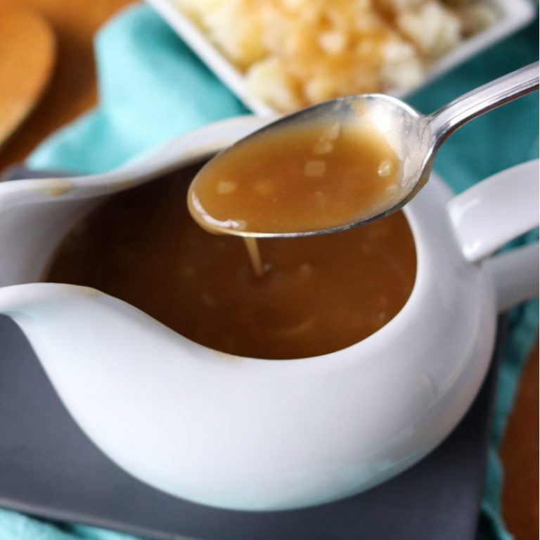 spoon with gravy over a gravy boat